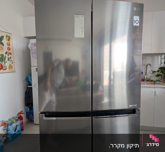 מקרר נירוסטה במטבח עם ציוד ביתי מסביב